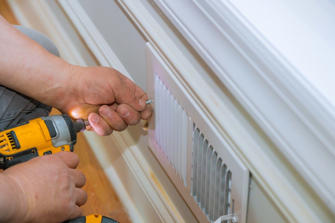 Maintenance repair, man is making the wall vent cover indoor central air conditioning, vents